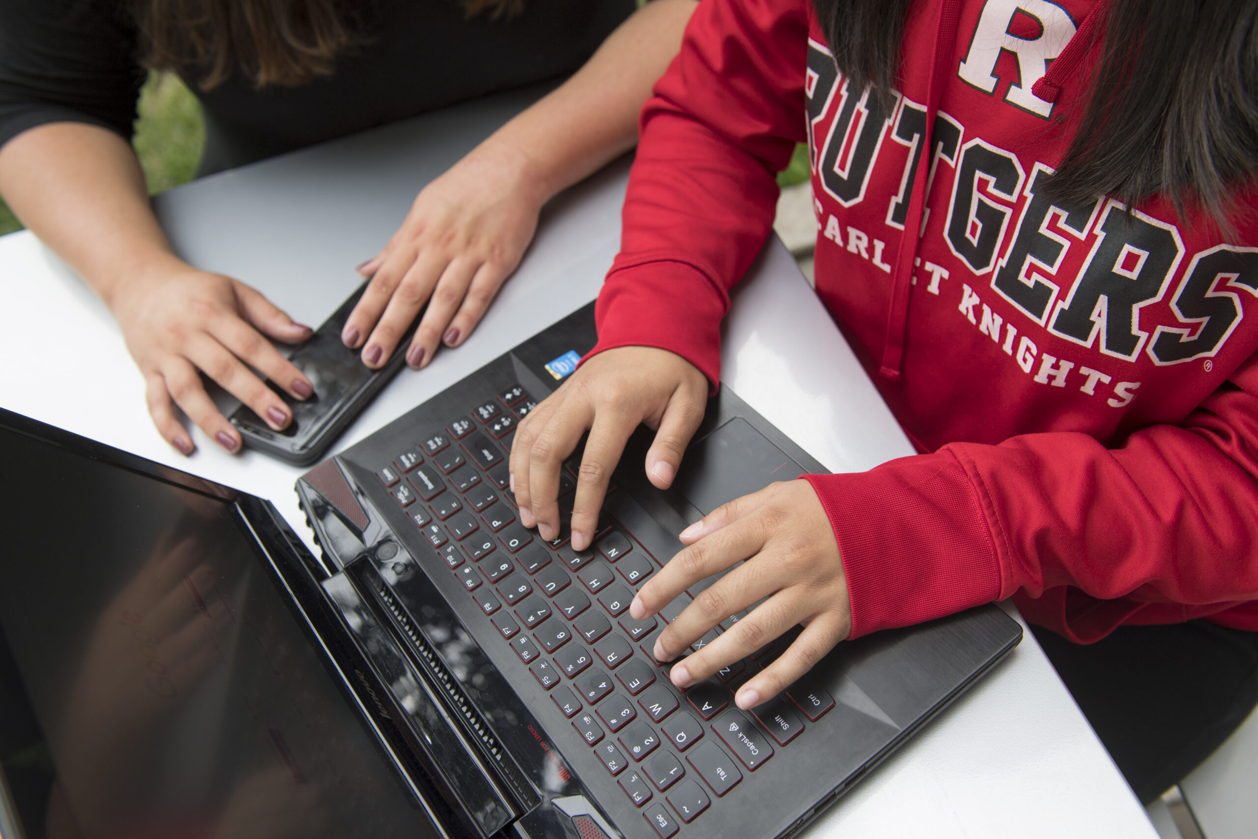 Hands type on a laptop