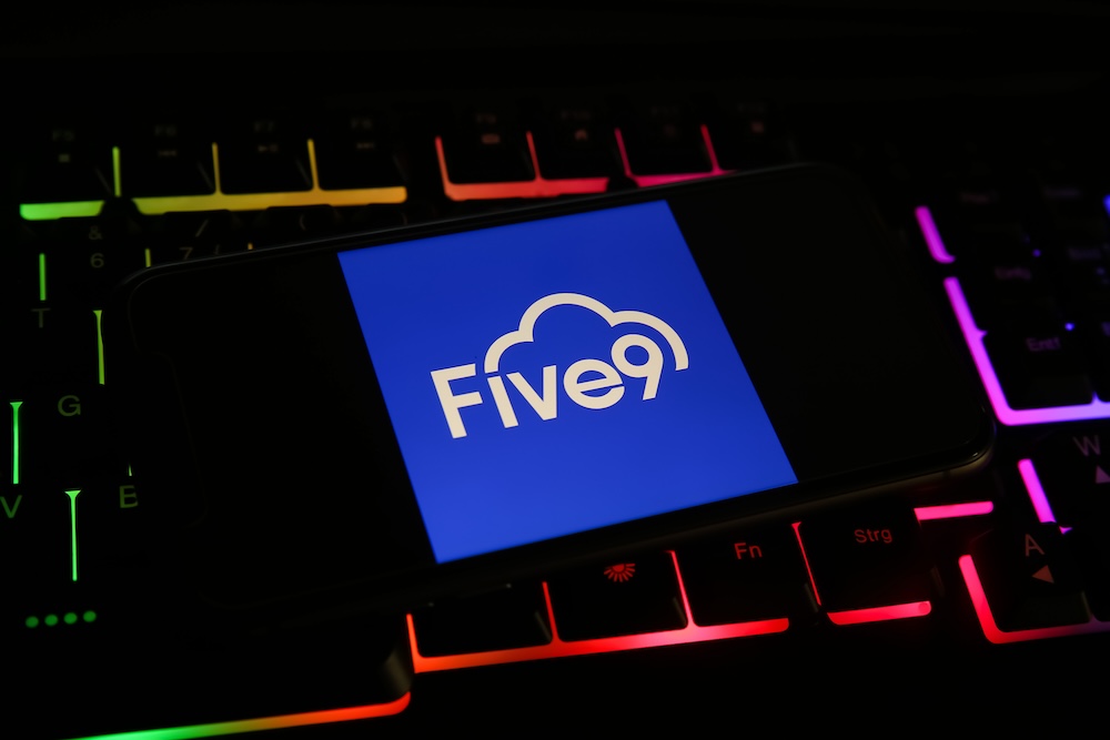 Viersen, Germany - May 1. 2021: Closeup of mobile phone screen with logo lettering of five9 on computer keyboard
